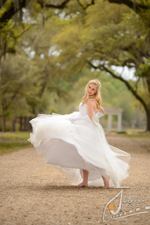 outdoor senior photos among oak trees with Spanish Moss