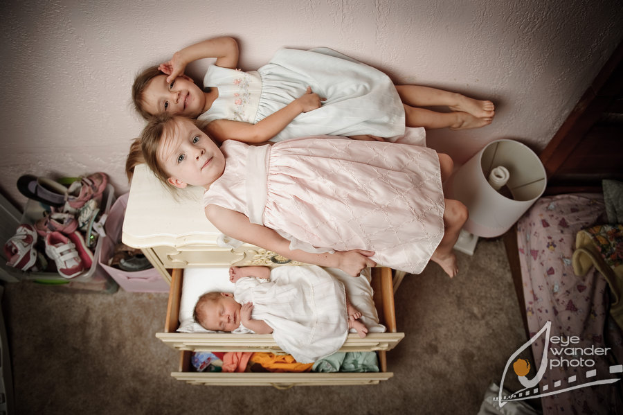 little girls in dresses with newborn sister