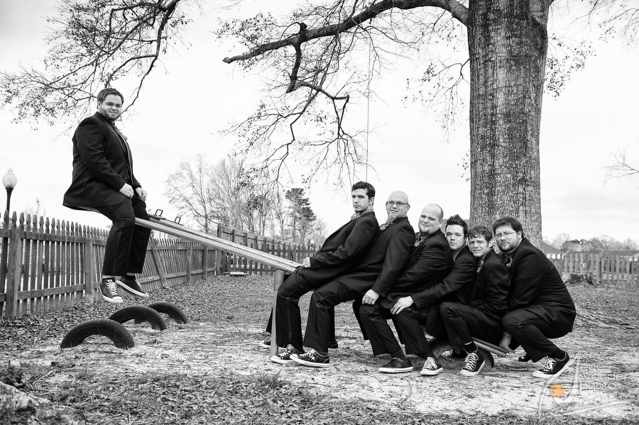 Baton Rouge Vineyard Wedding The Lakehouse Groom and Groomsmen sit on Seesaw in Playground