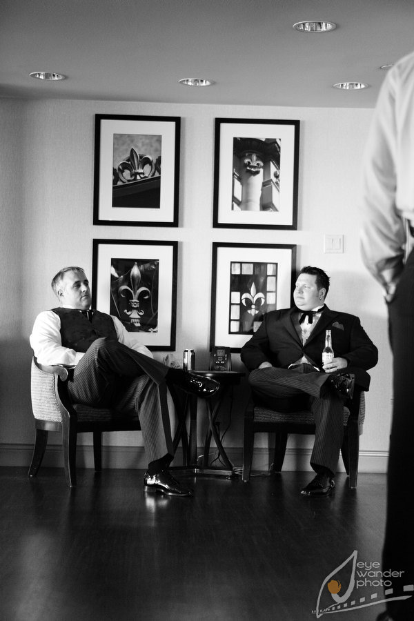 New Orleans Wedding Groomsmen drink beer in front of Fleur De Lis