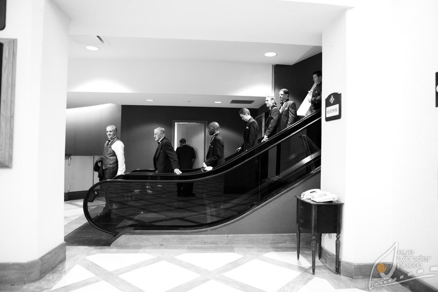 New Orleans Wedding Groomsmen descend Hotel Escalator