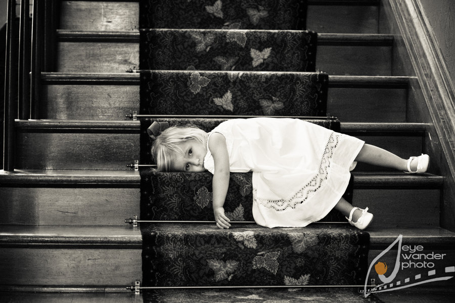 Kids at weddings tired flower girl laying on staircase